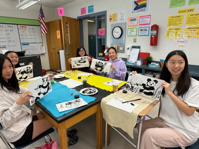 九年級的女同學展示自己所畫的貓熊作品.