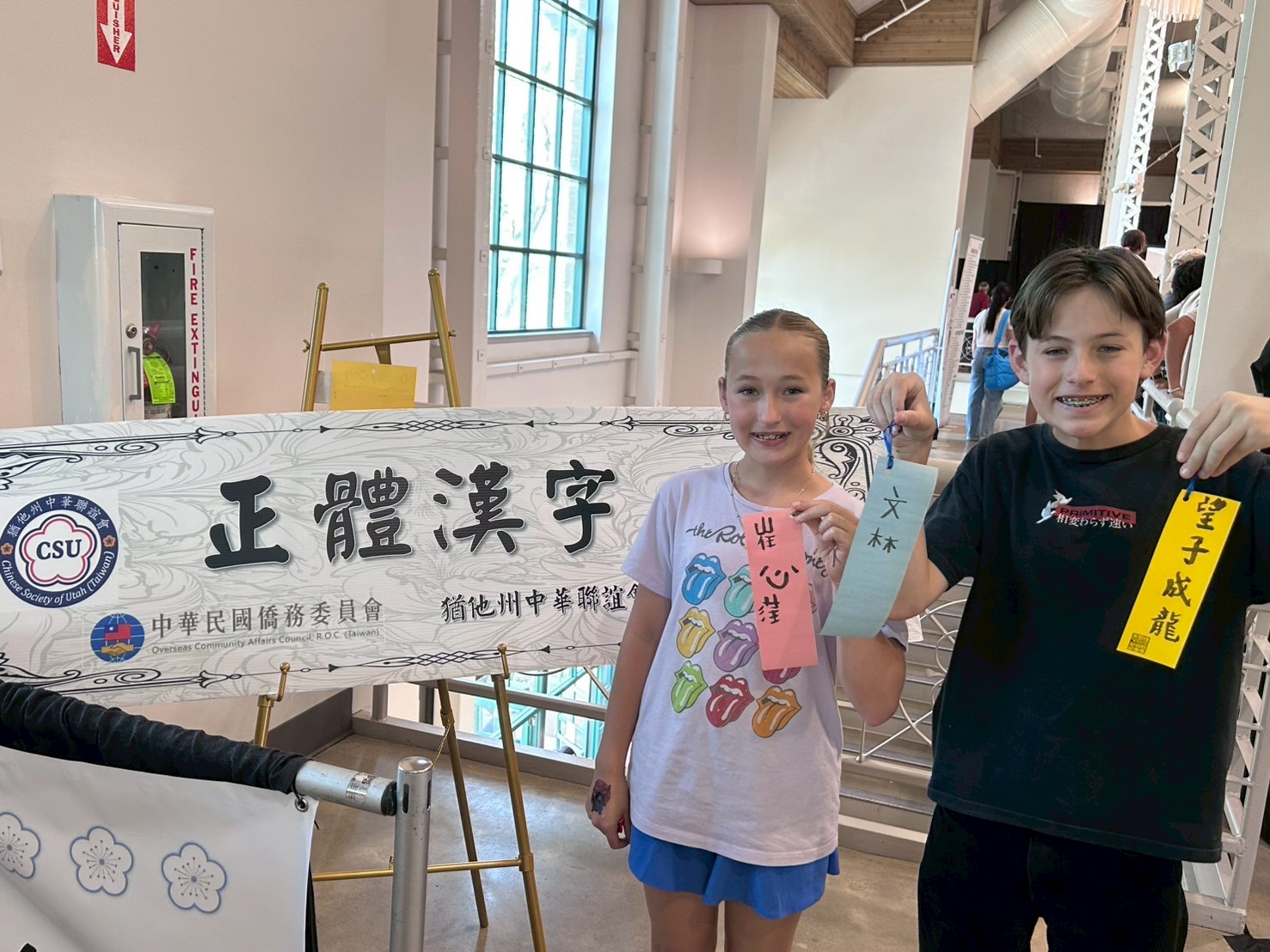 兩位小朋友快樂地展示他們的書法作品