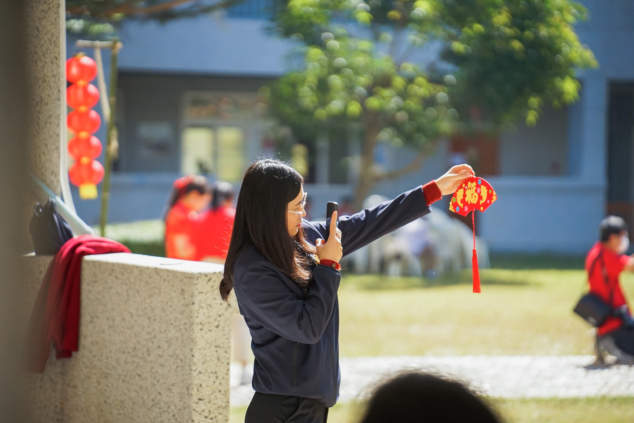 以漢字和圖像拼製而成的扇子含藏著祝福之意，民眾滿意地拿著自己的作品拍照。