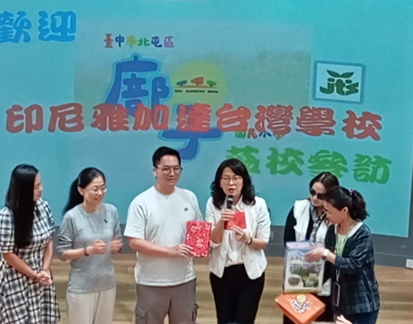 賴旻沅副會長(左三)與閔柏惠校長(右三)互贈錦旗與紀念品