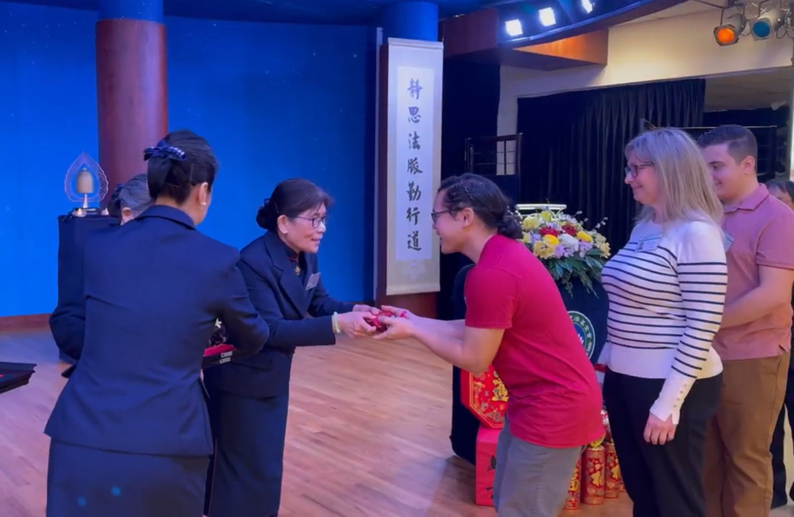 TCML學生上台，從基金會執行長手中接過象徵祝福與智慧的福慧紅包