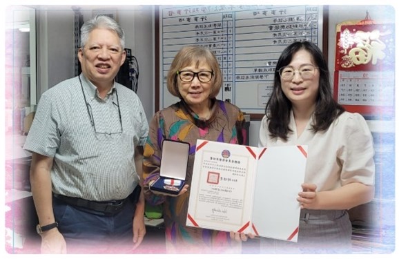 僑務秘書吳婉郡(右)代表僑委會頒贈20年教師獎勵勳章予吳惠真老師(中)