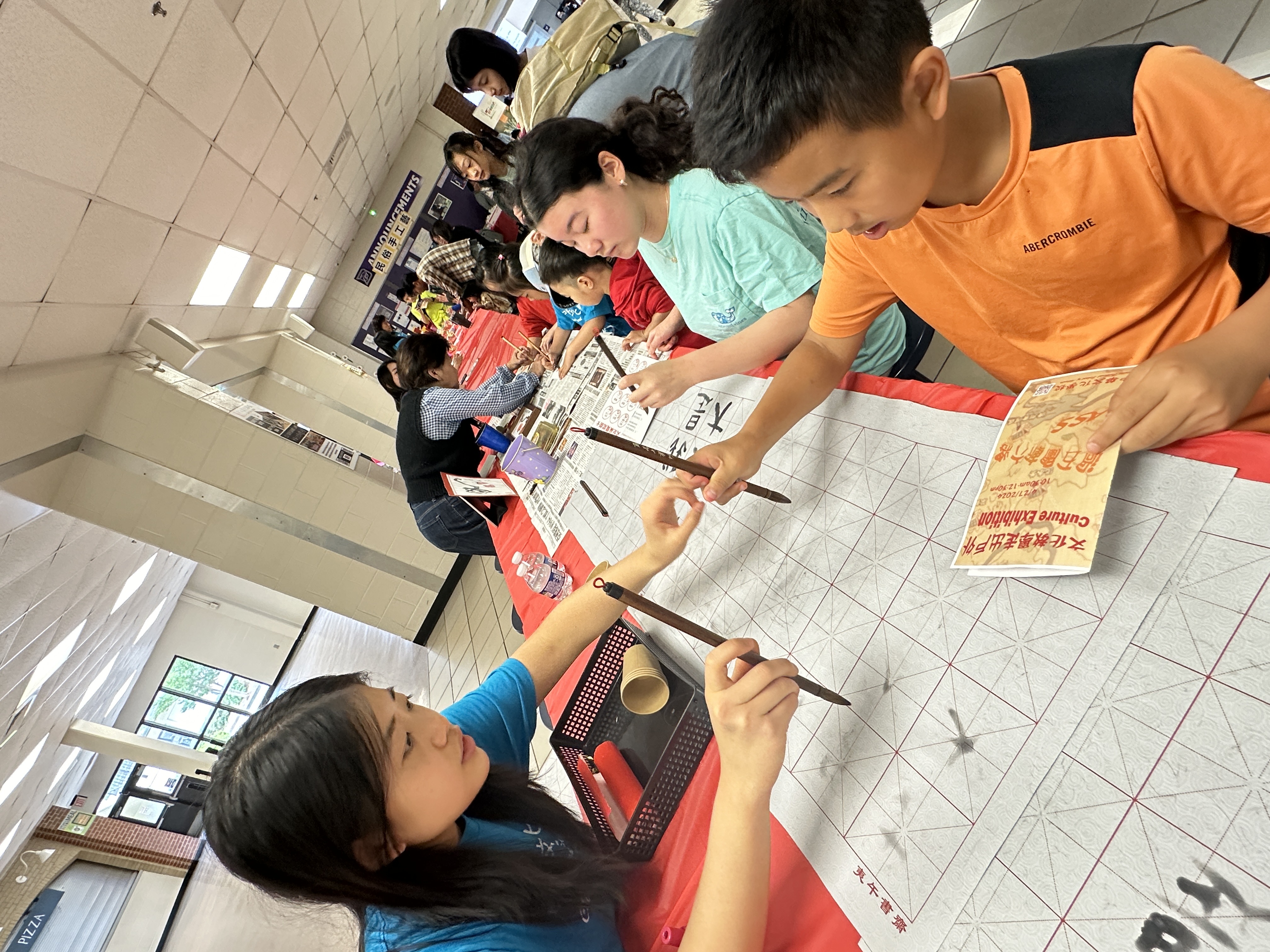 參與學生於書法攤位認真練習寫毛筆字