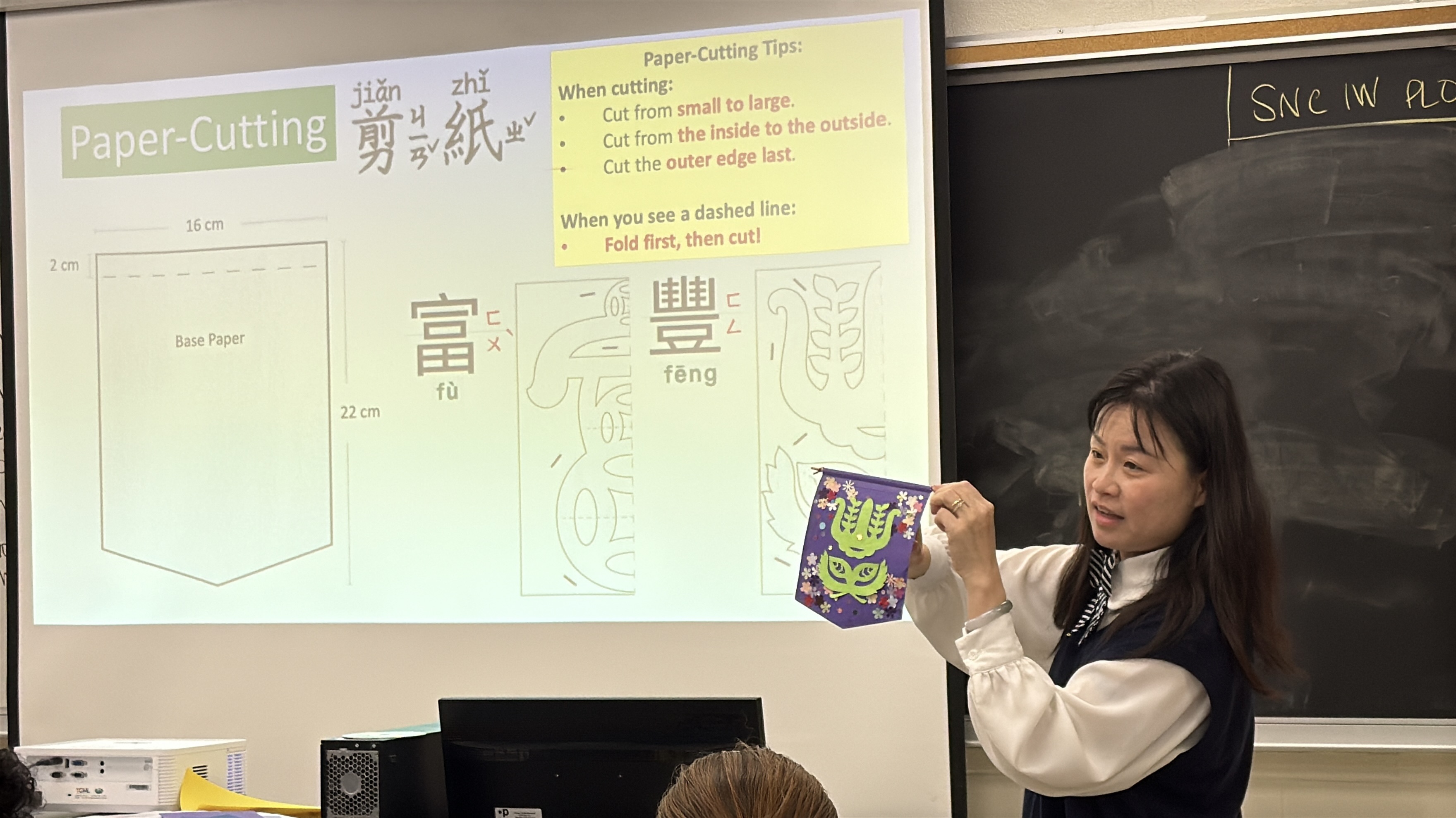 結合漢字造形與傳統剪紙技巧，賴芳敏老師透過投影講義向學員示範「富」與「豐」字文字旗的製作訣竅，帶領成人中文班學員體驗手作樂趣。