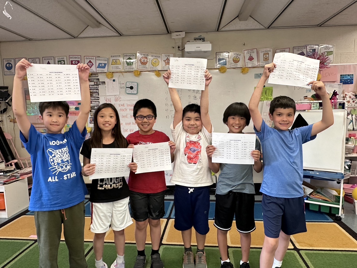 三年級完成認字馬拉松活動後，舉起考卷開心合照