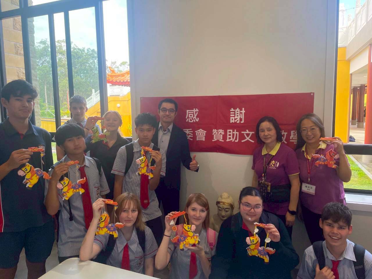 學生拿著自己的作品和中心主任合影