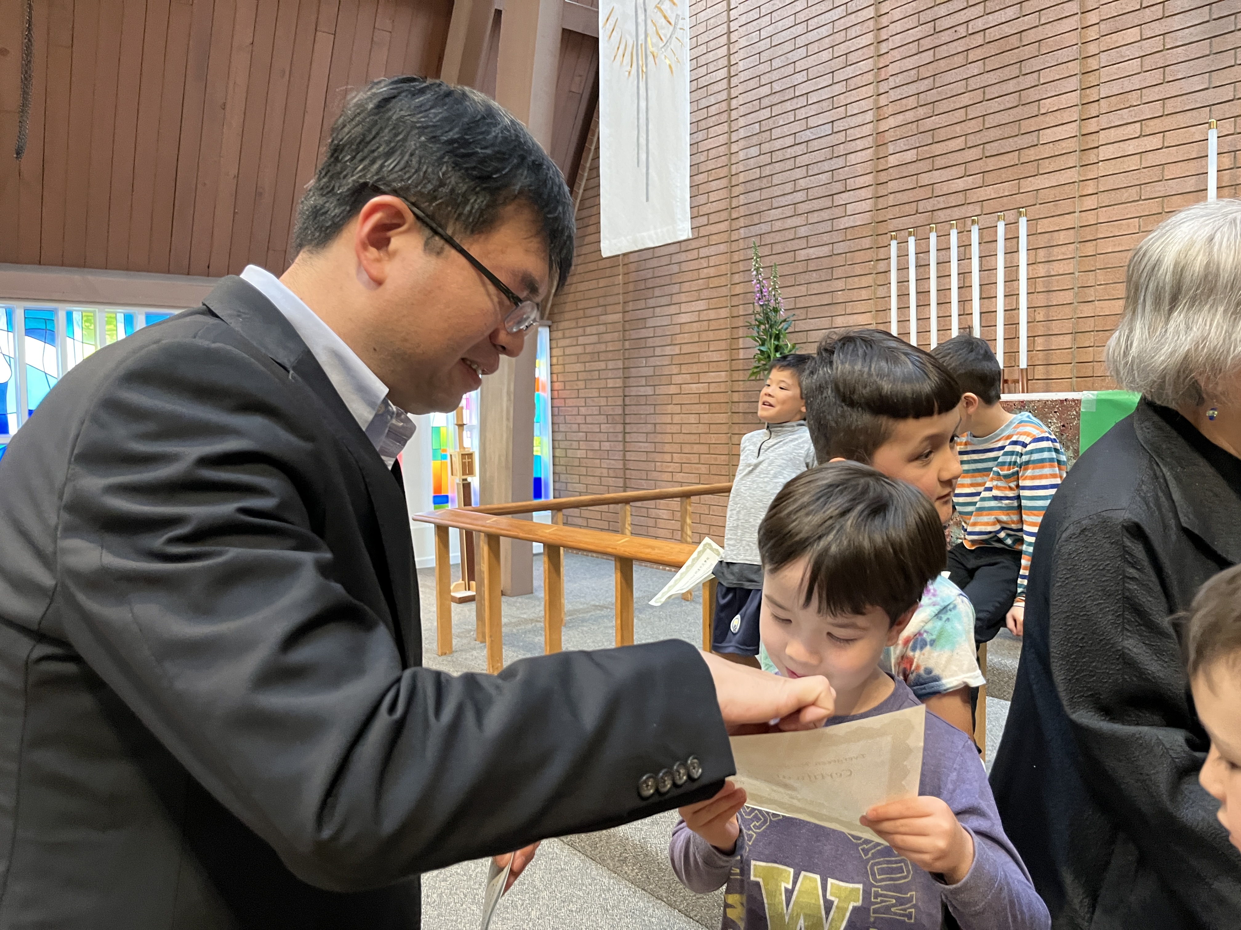 拿到證書的孩子與主任熱烈討論證書上的華文意義