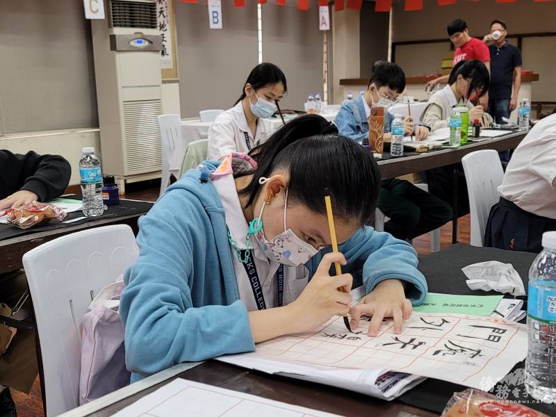 參賽者在主辦單位所分發的大楷紙上揮毫