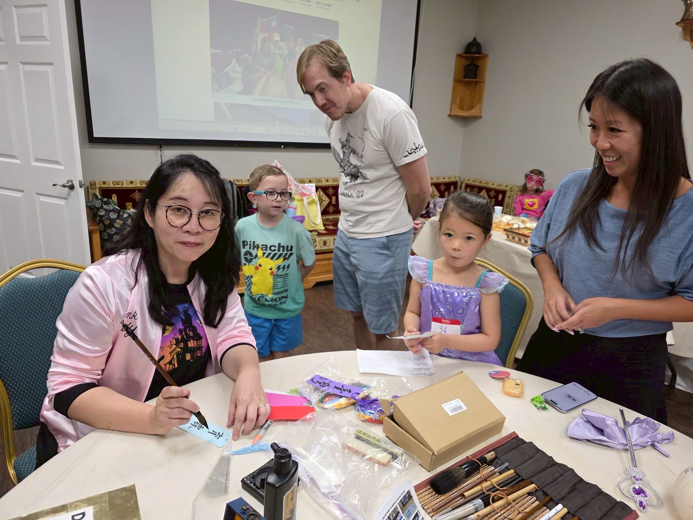 僑務顧問兼台灣同鄉會會長羅唯嘉指導學生們寫書簽