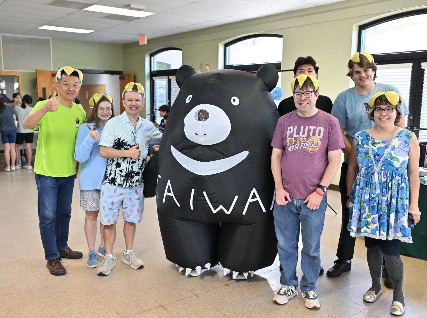 洛麗臺灣華語文學習中心學生們頭戴柚子瓜皮帽與臺灣黑熊人偶合影