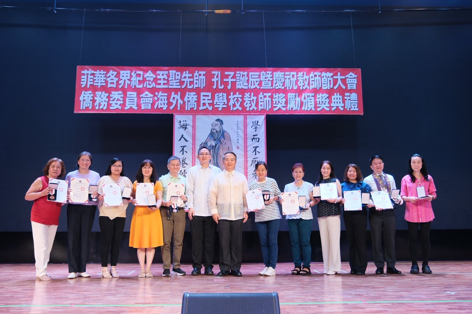 大使周民淦頒贈獎座給執教資深優良教師，菲華文教服務中心主任莊博智同臺見證