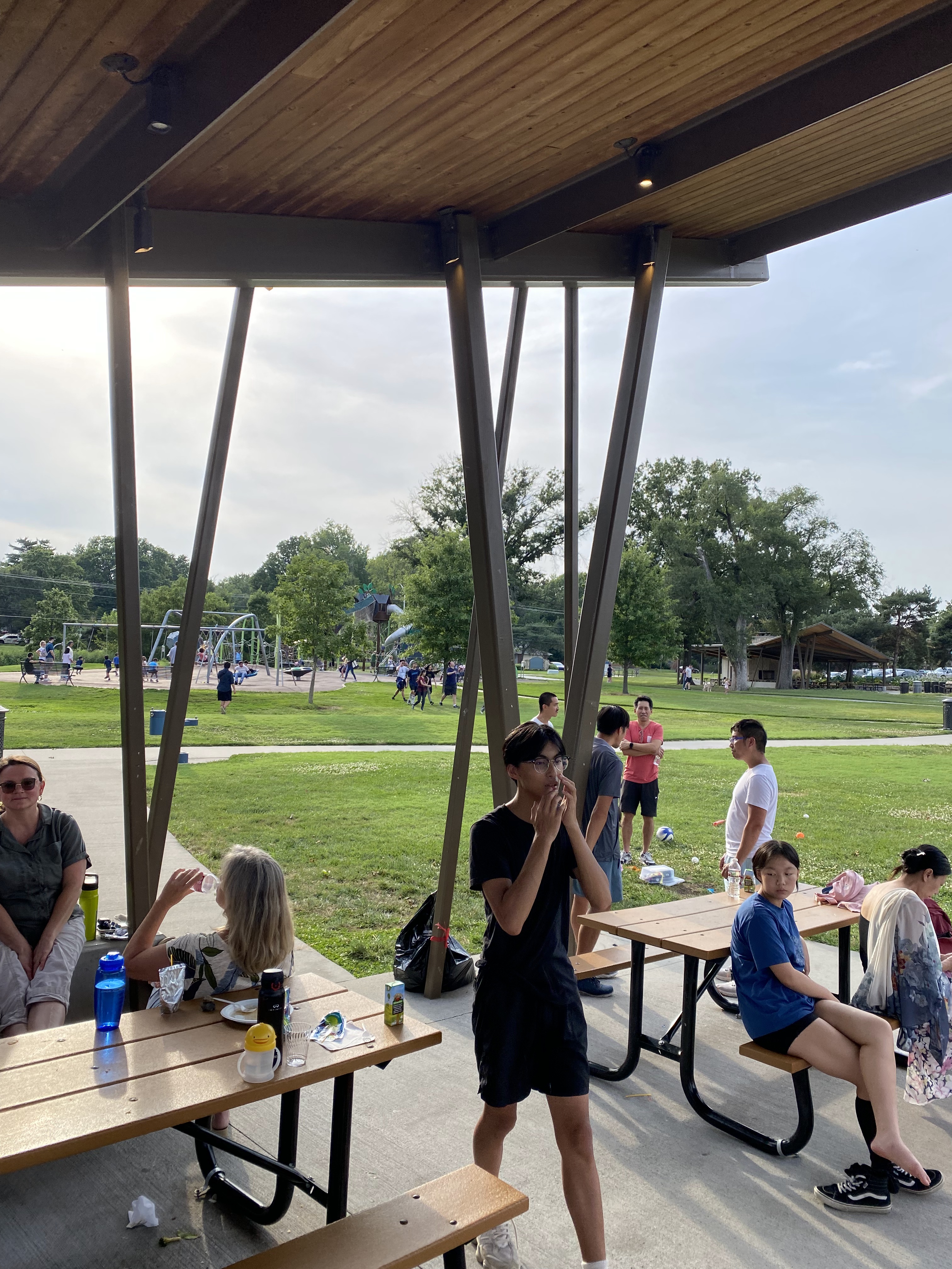 家長老師董事談天討論 學生們在遊戲設施區玩耍