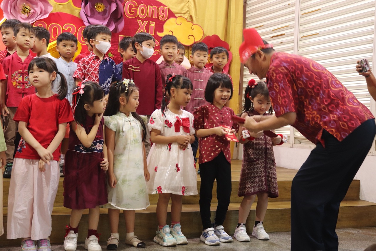 幼生雙手拿紅包象徵接福