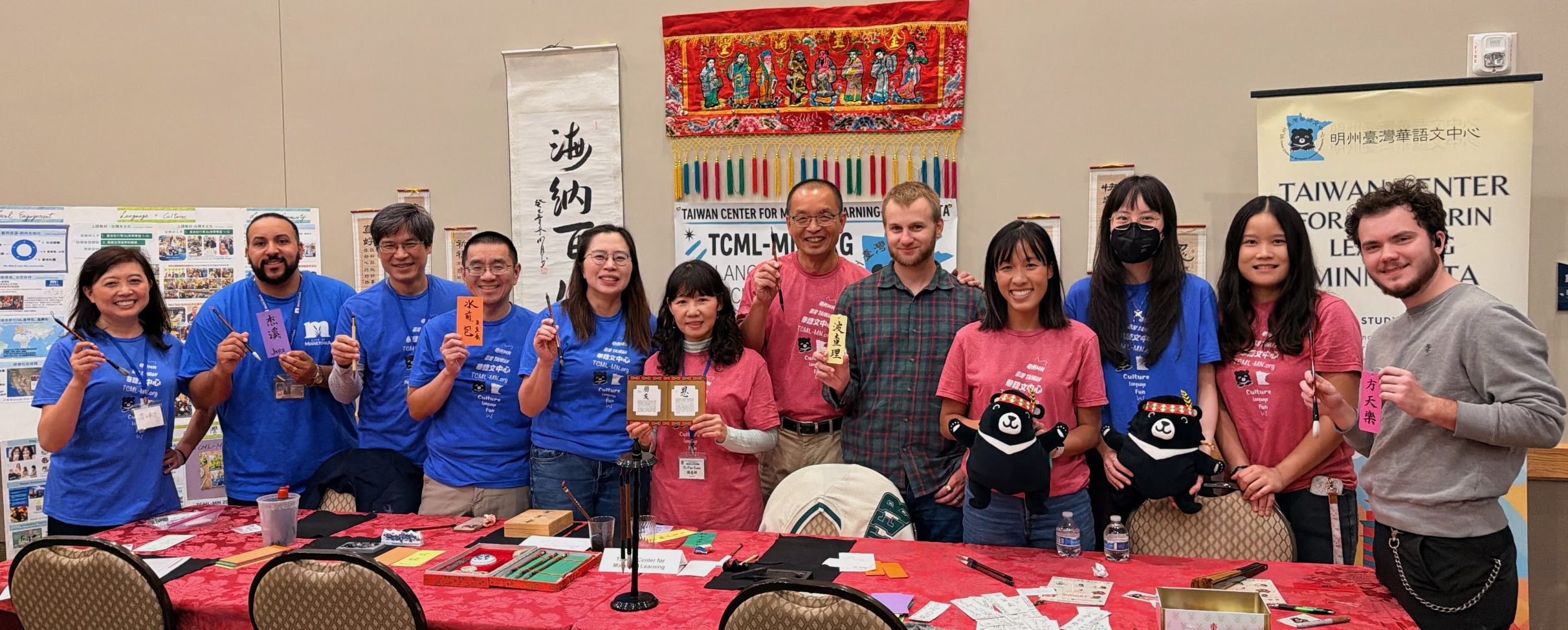 Minnetonka市首次舉辦中秋節活動，TCML-MN 也首次與市政府合作，11位行政團隊、教師與學生穿著 TCML-MN T-shirt 共襄盛舉，左起第二位為Minnetonka市活動代表 Jayce。Minnetonka city hosted its first Mid-Autumn Festival, and TCML-MN joined the city for its first collaboration. 11 TCML-MN staff members, teachers, and students participated in the celebration wearing TCML-MN T-shirts. Jayce, second from the left, represented the City of Minnetonka at the event.
