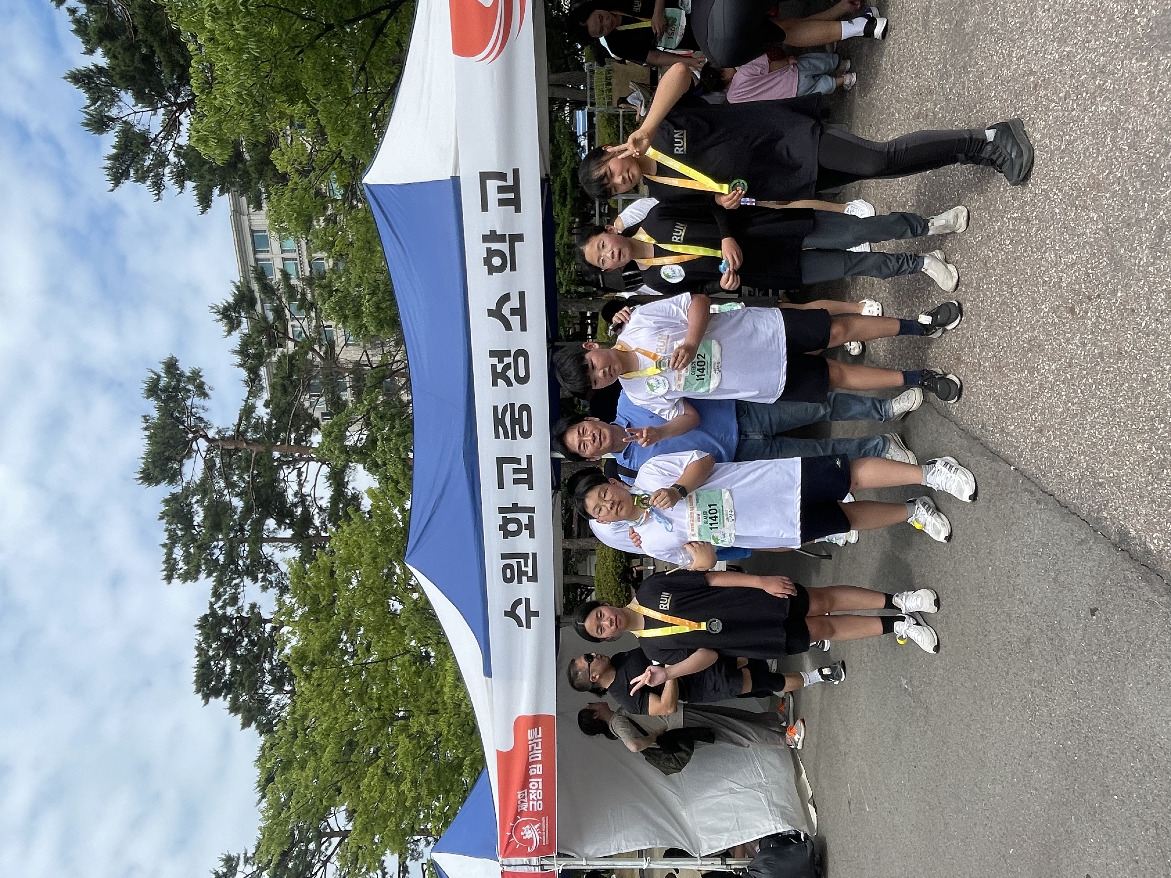 成功完跑10公里,於學校帳篷前與校長合影留念，展現完成賽程的成就感