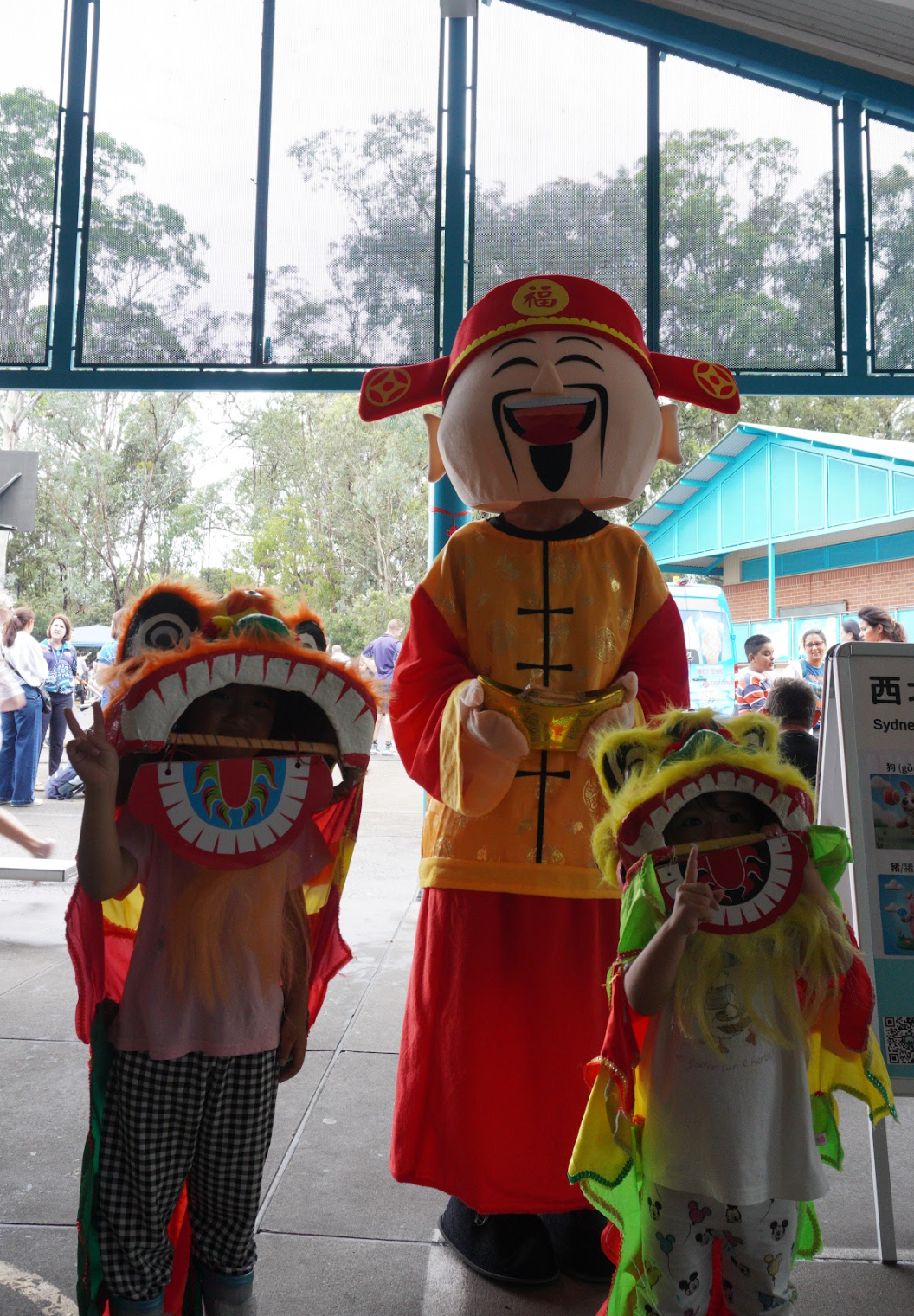 財神爺與戴著可愛小獅頭的小朋友合影，現場喜氣洋洋。