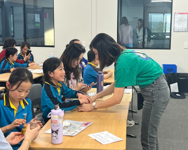 家長進班陪同孩子製作輕黏土月餅，親子共學氣氛溫馨。